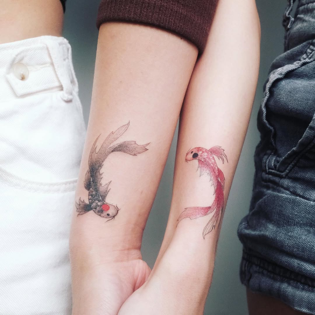 Stylish sister tattoos featuring koi fish.