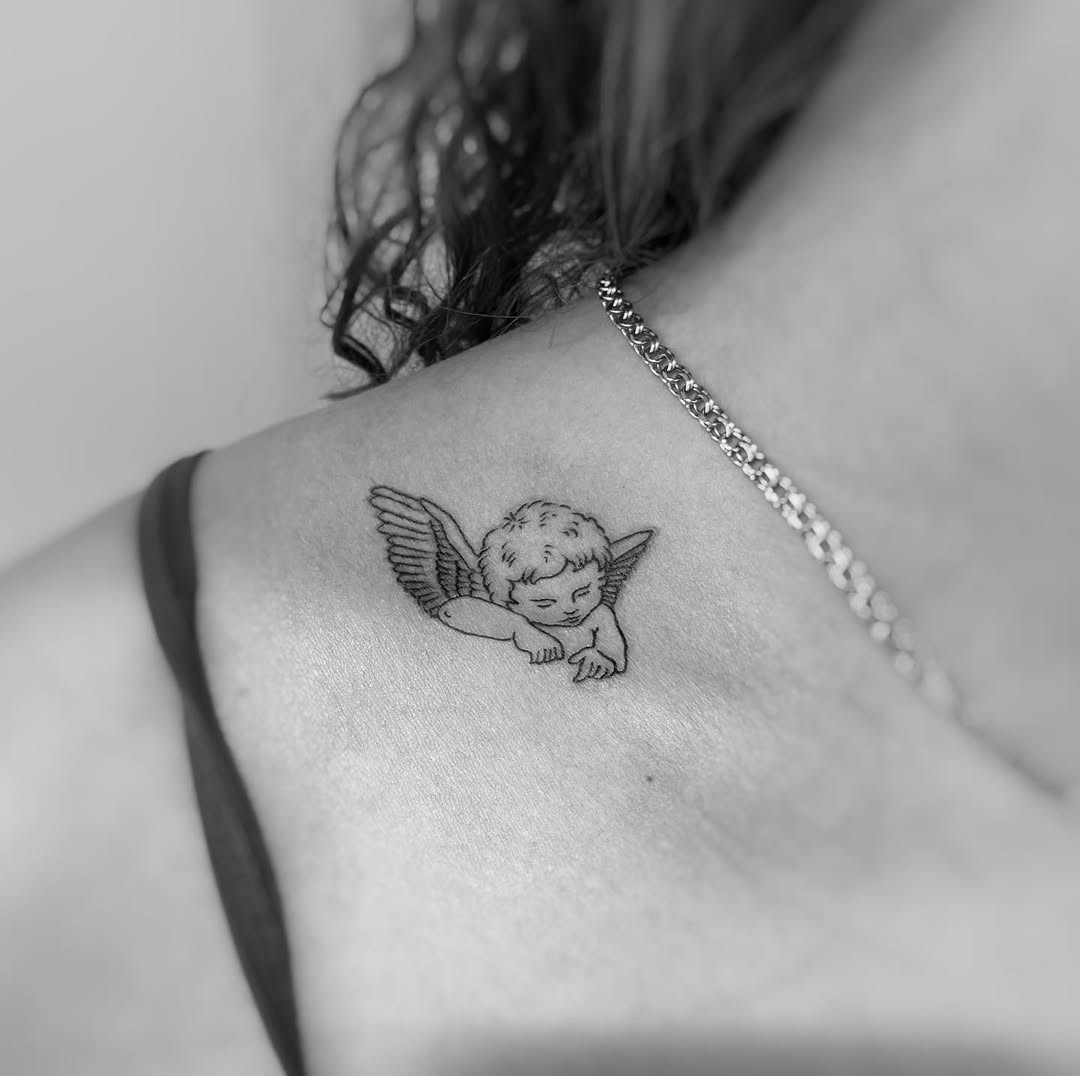 Delicate cherub tattoo on shoulder