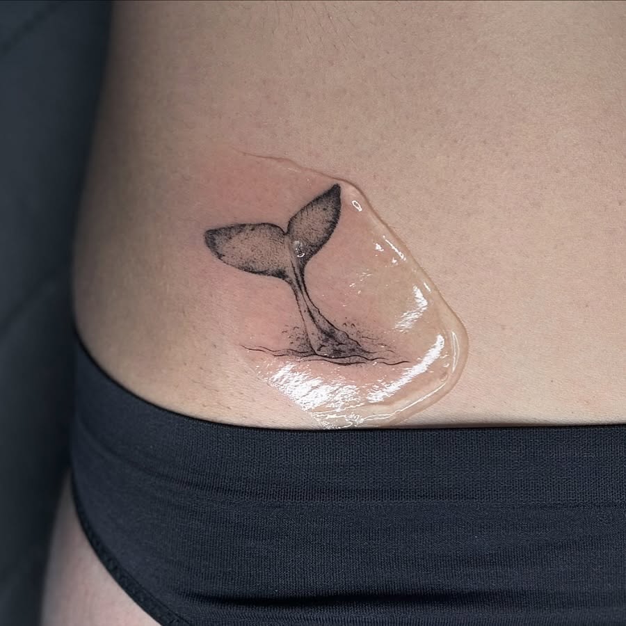 Elegant minimalist whale tail tattoo design