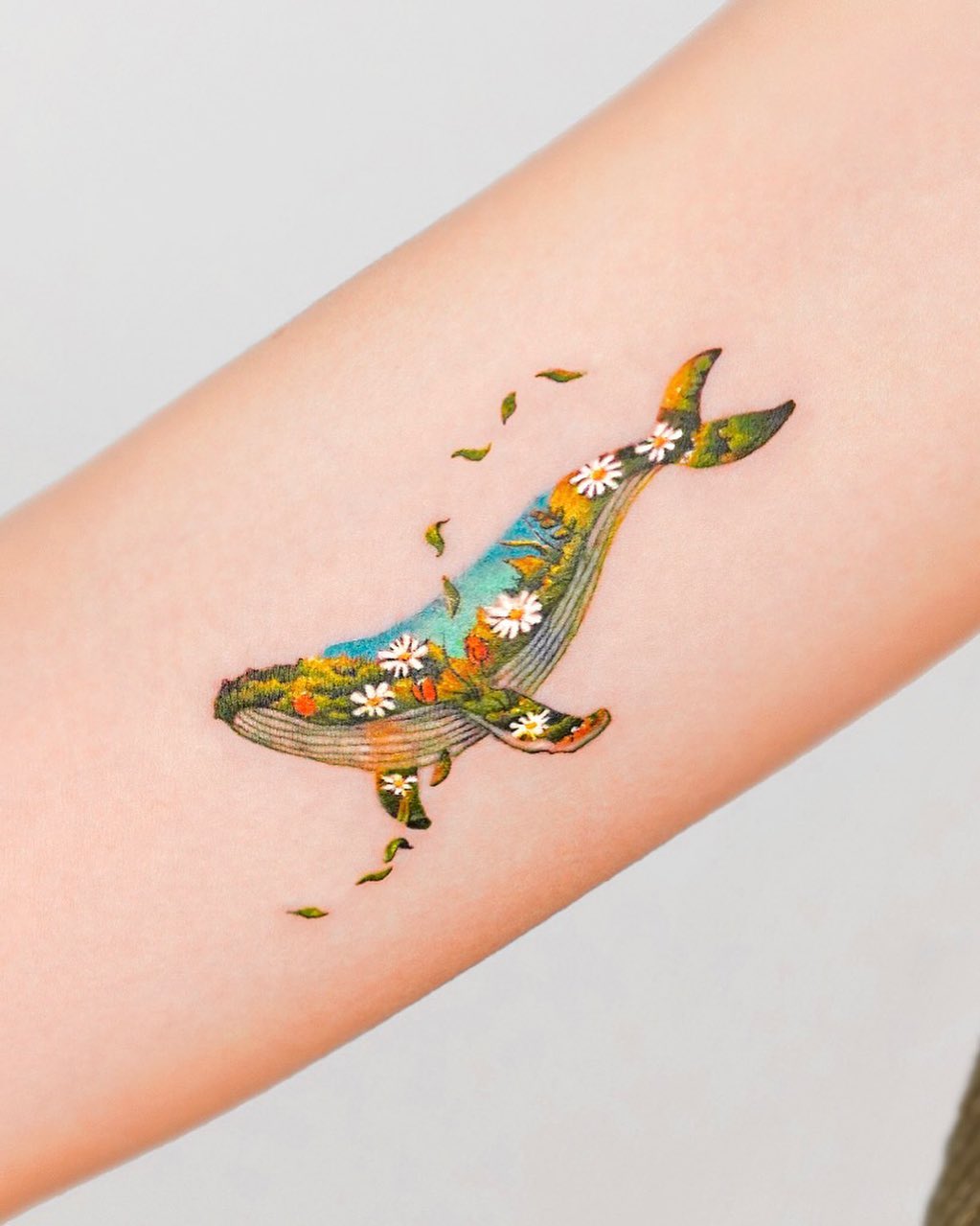 Colorful floral whale tattoo on the arm