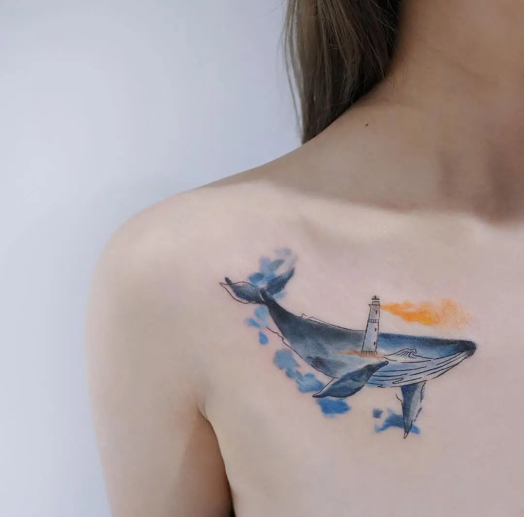 A vibrant whale tattoo with lighthouse detail