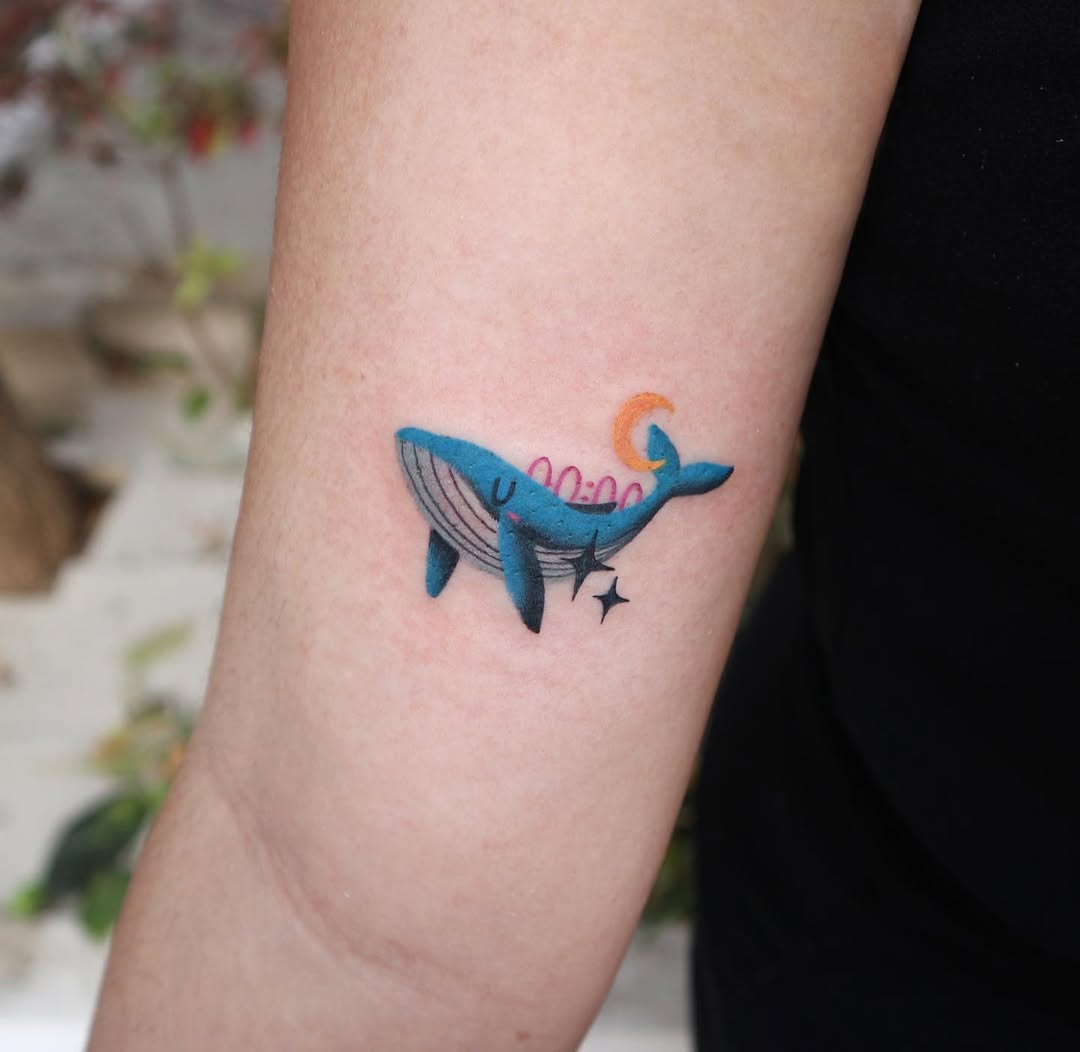 Colorful minimalist whale tattoo on the arm