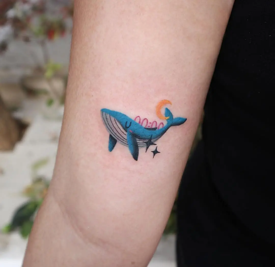 Colorful minimalist whale tattoo on the arm