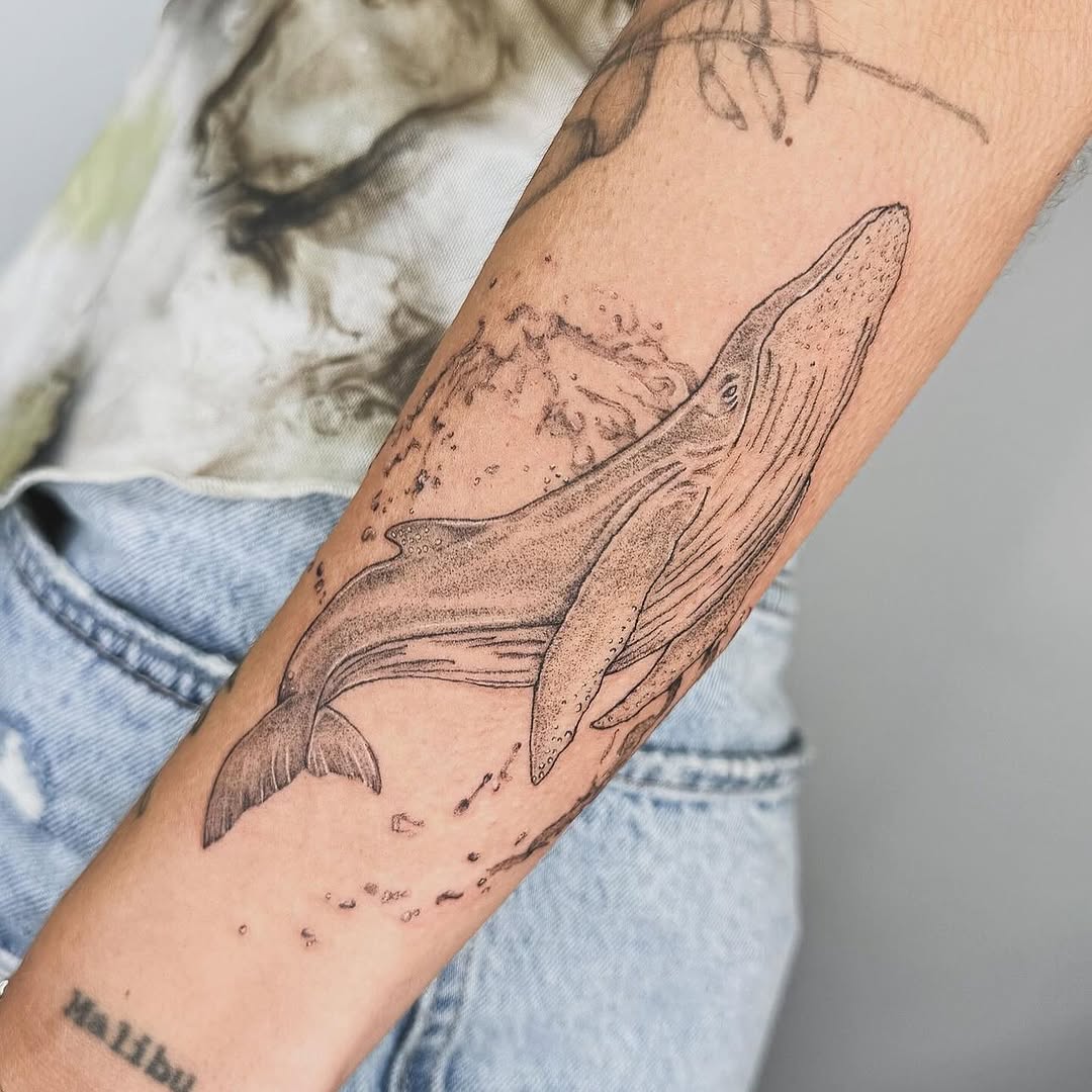 Elegant whale tattoo showcasing fine line artistry