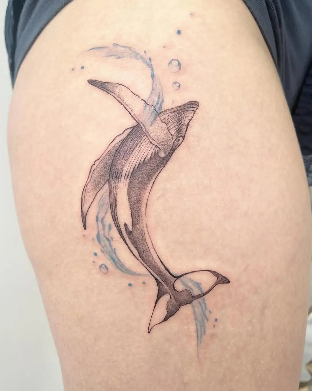 Elegant minimalist whale tattoo swimming gracefully