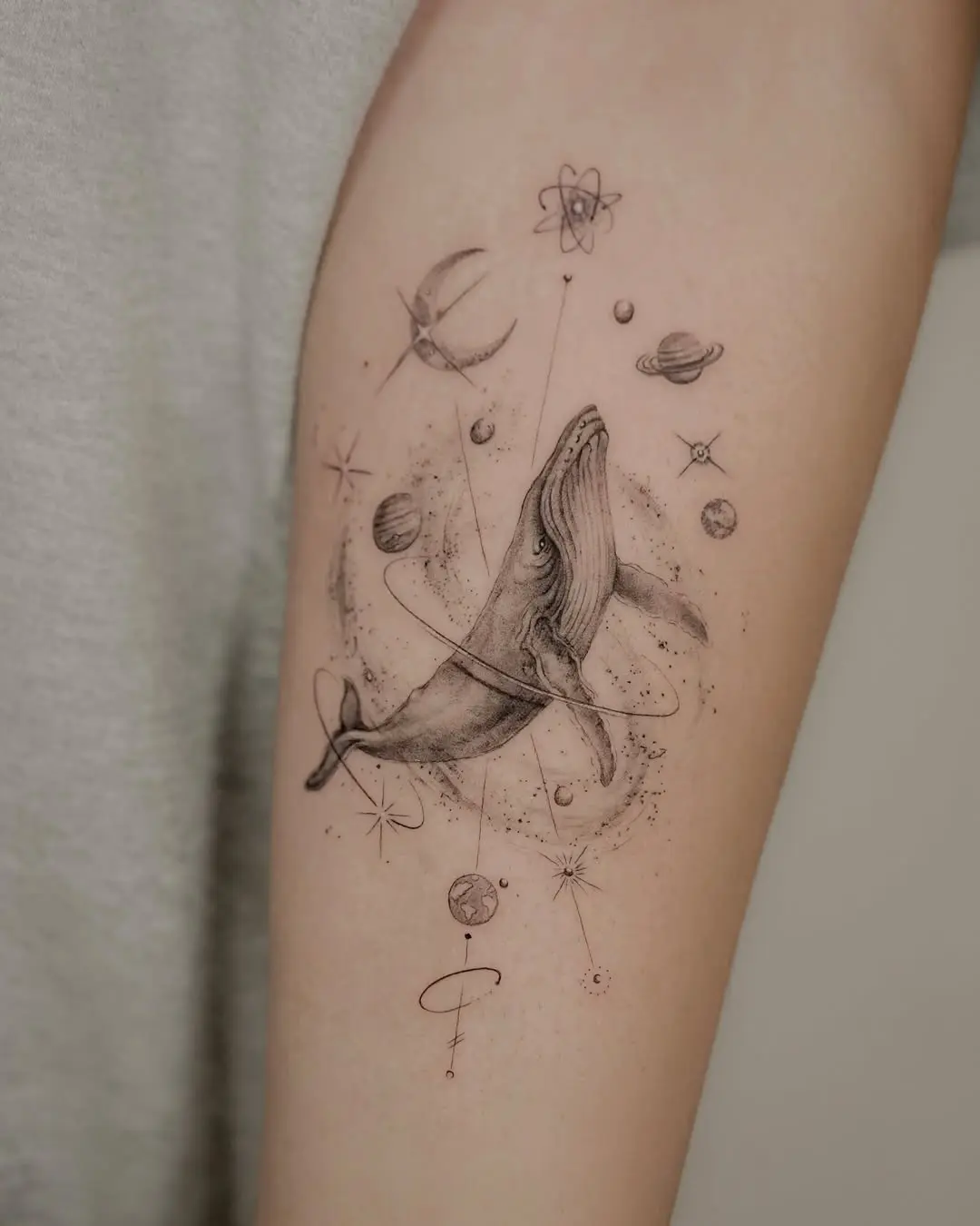 Whimsical whale tattoo with cosmic elements