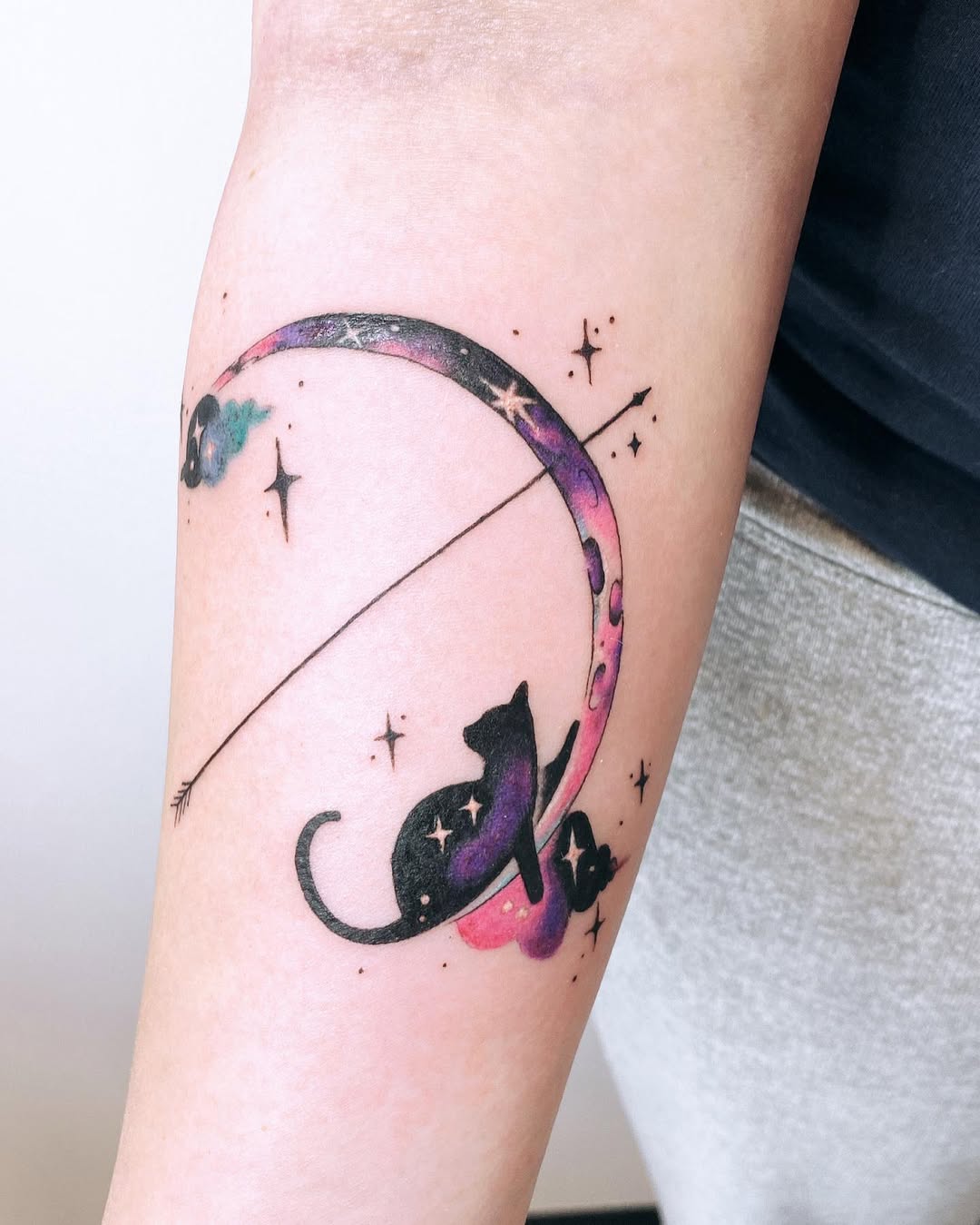 Whimsical arrow tattoo with moon and cats