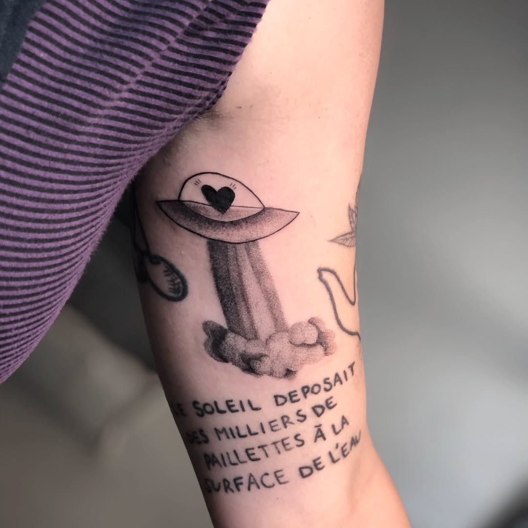 Whimsical alien spaceship tattoo with text