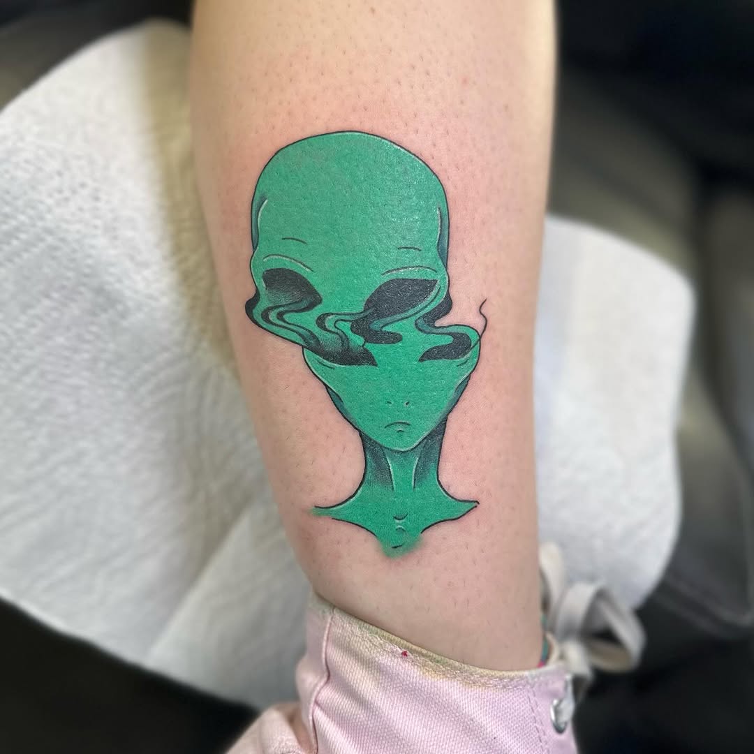 Vibrant green alien tattoo with eerie vibes