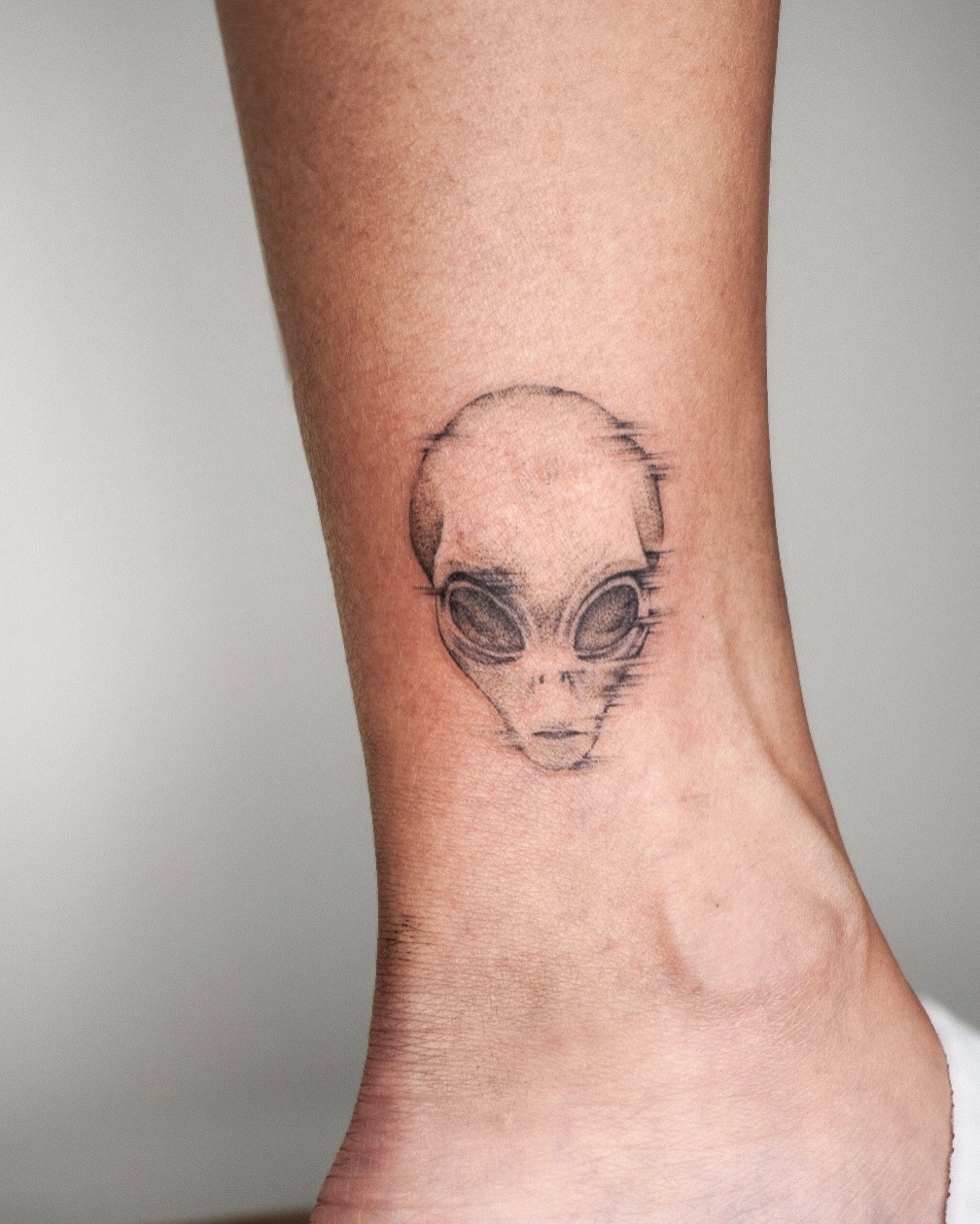 Intriguing alien design inked on ankle