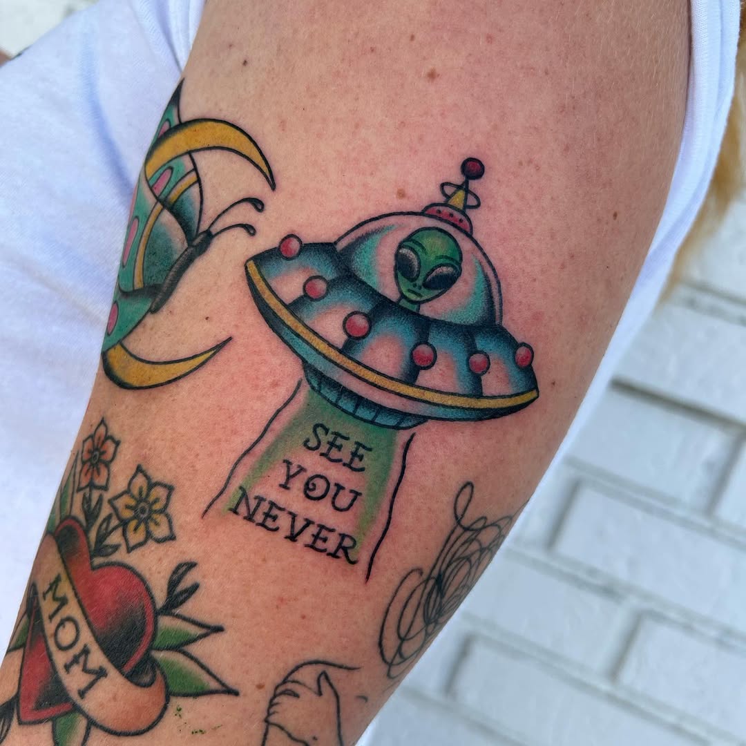 Playful alien spaceship tattoo with vibrant colors