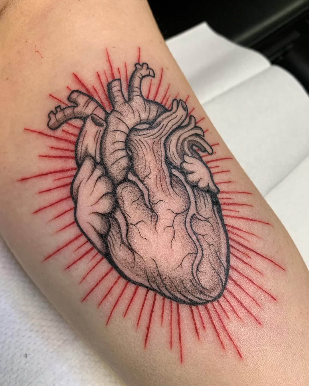 Stunning anatomical heart tattoo with vibrant rays