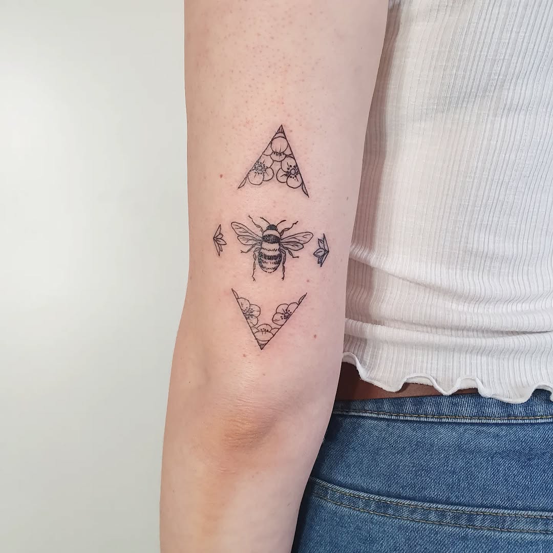 Stylish geometric bee tattoo with floral accents