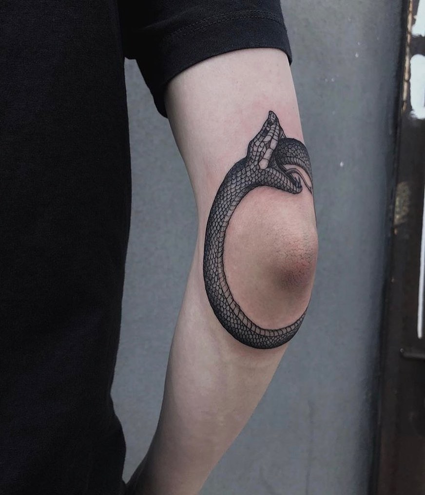 Intricate snake design wraps elegantly around elbow