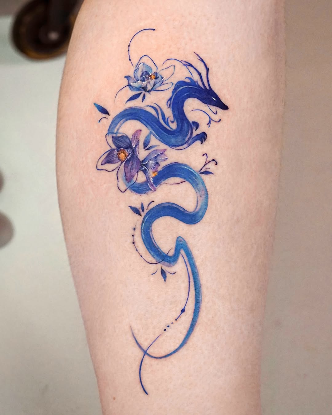 Intricate blue dragon design with floral accents