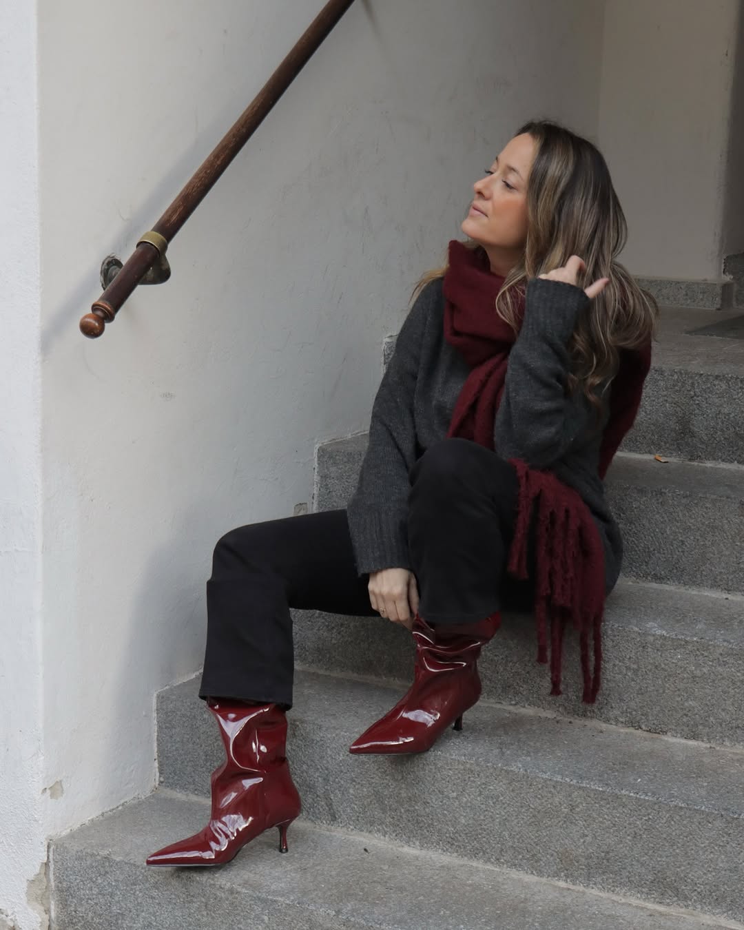 Chic red boots elevate minimalist ensemble effortlessly