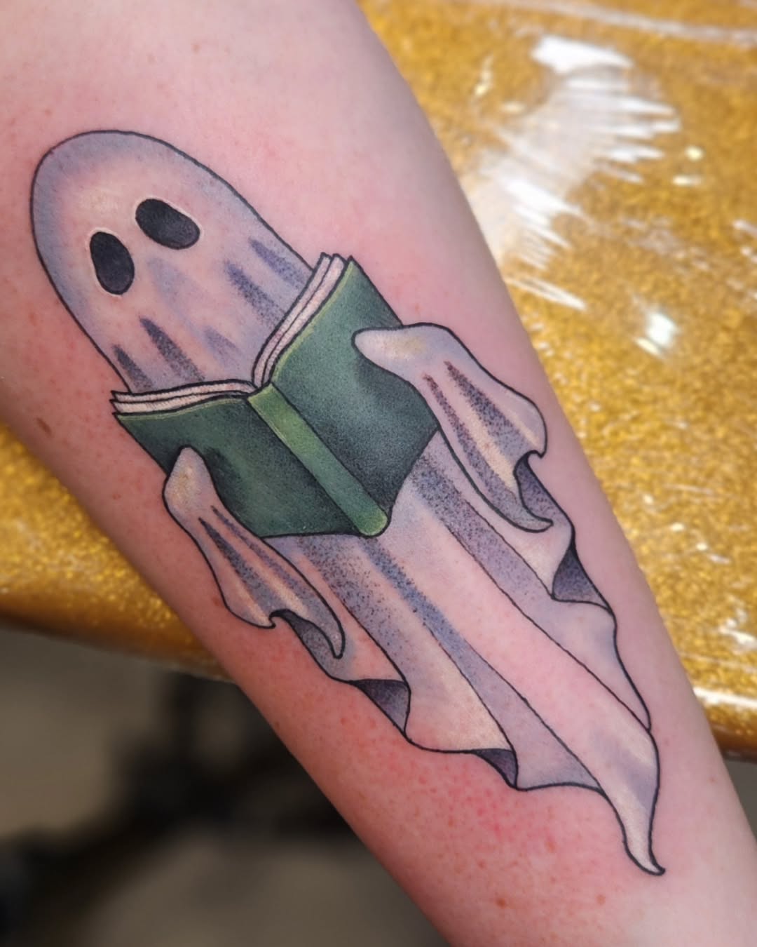 Whimsical ghost reading a book tattoo design