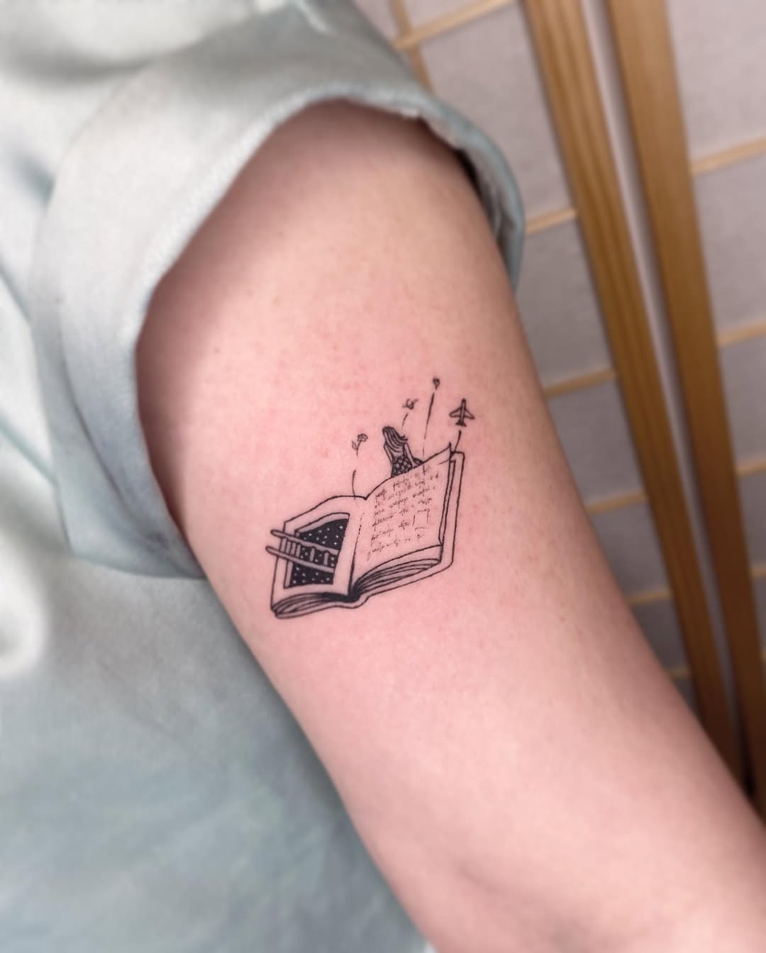 Charming book tattoo with a whimsical bird