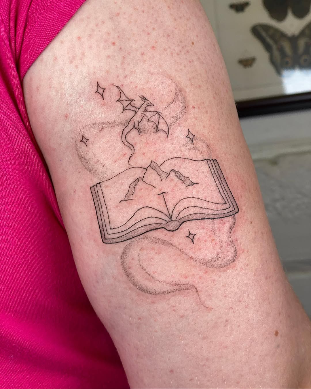 Imaginative book tattoo with a dragon motif