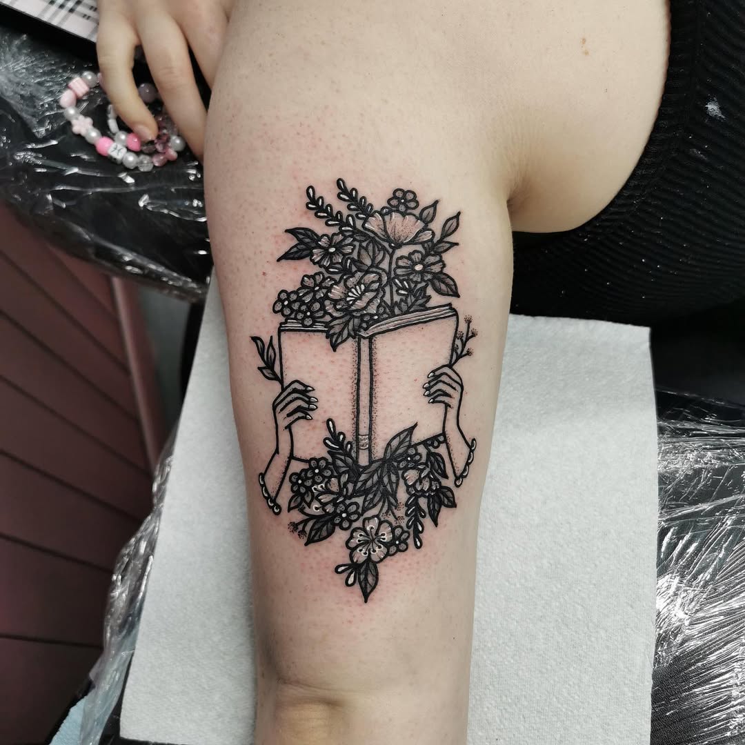 Floral Book Tattoo with Hands Holding Open Pages