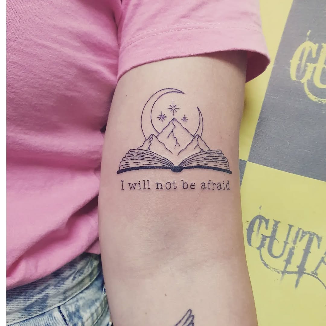 Inspiring book-themed tattoo with mountain scene