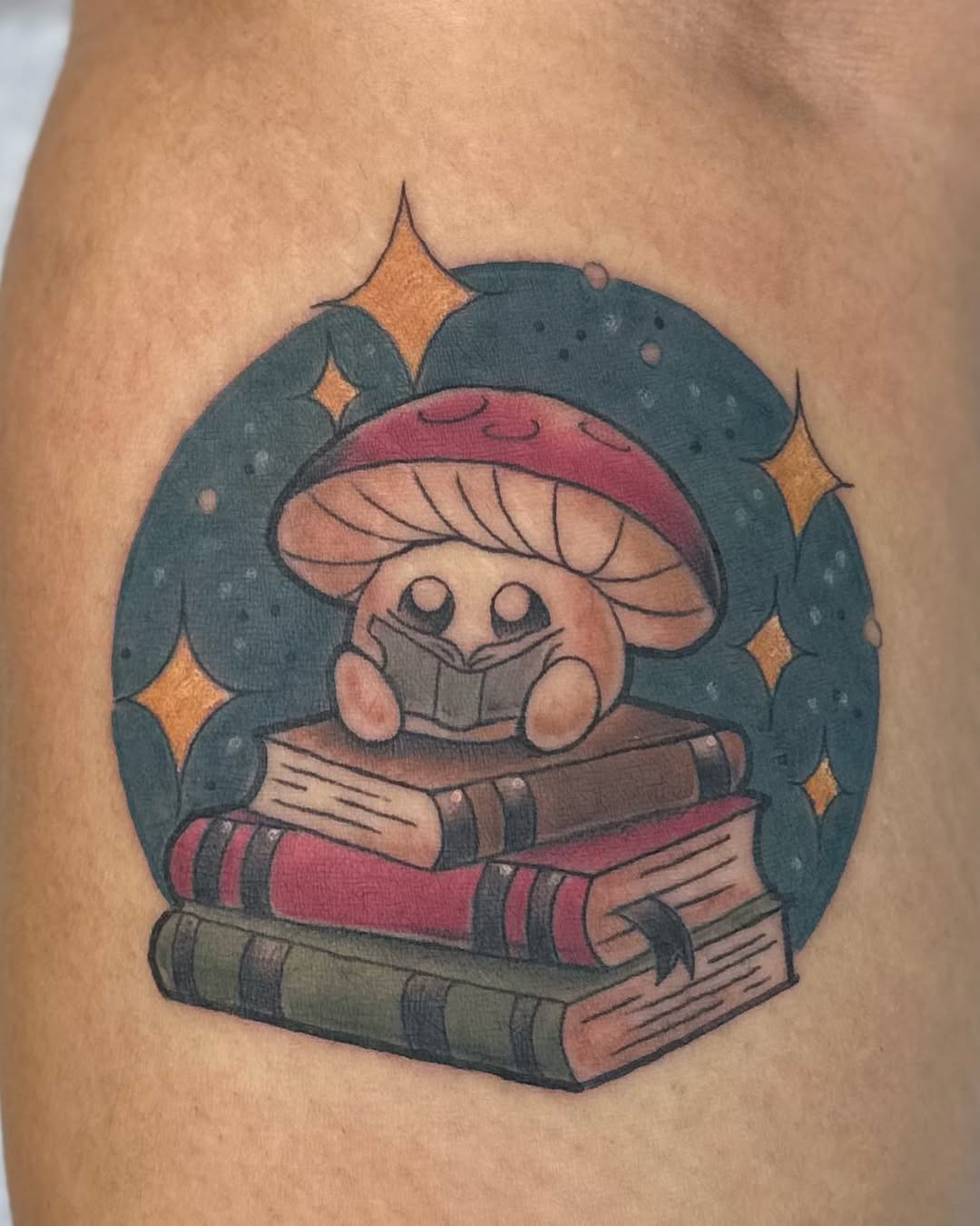 Whimsical mushroom reading on stacked books tattoo