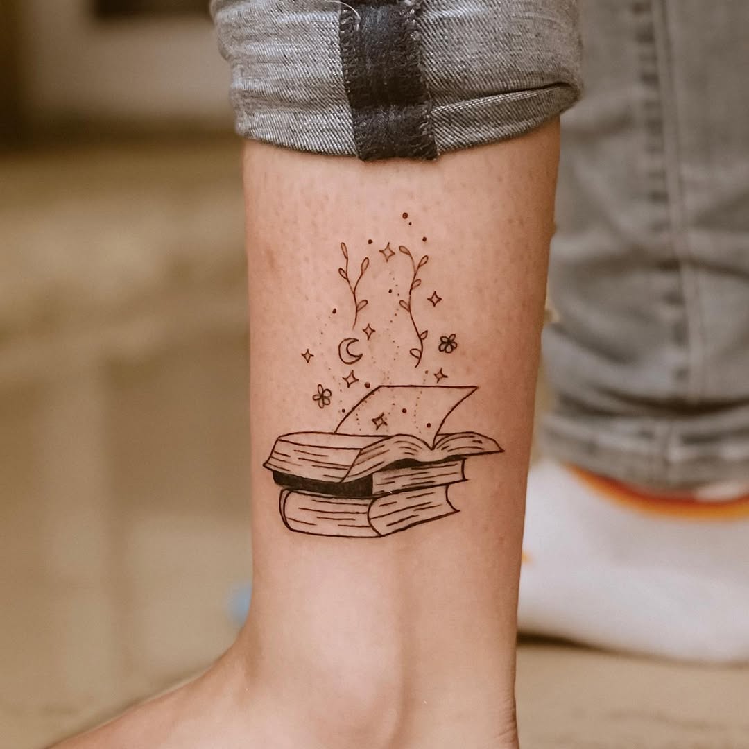 Whimsical book tattoo with floral accents