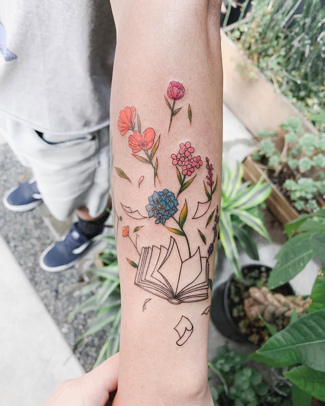 Colorful floral book tattoo design highlights creativity