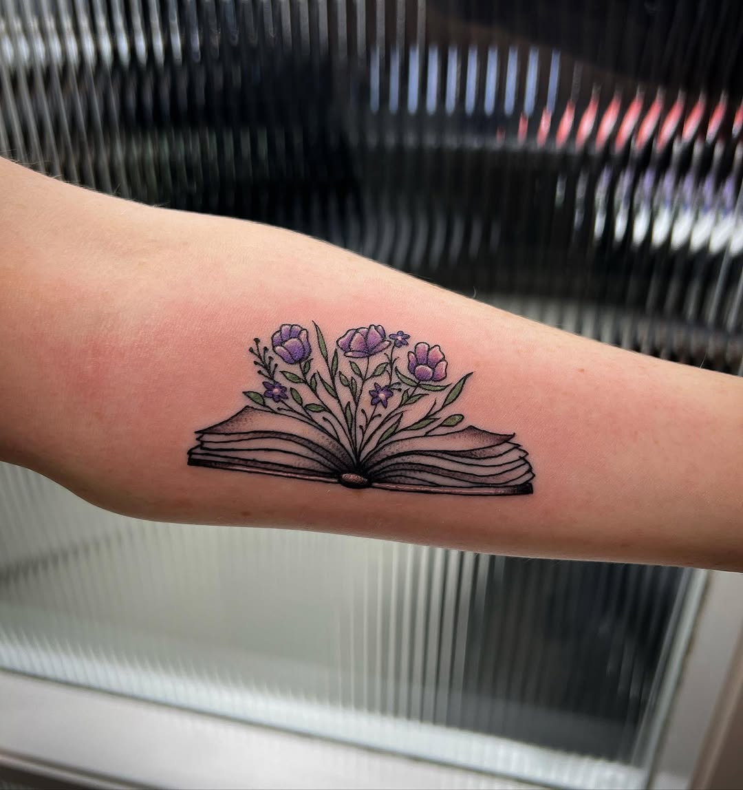 Elegant flora sprouting from an open book tattoo