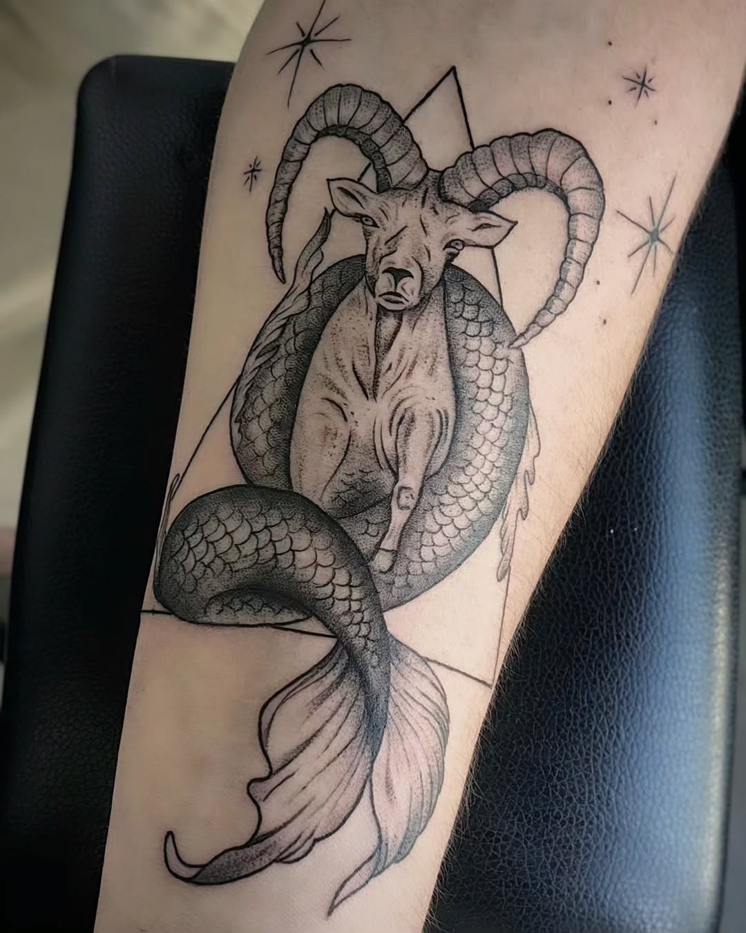 Intricate Capricorn tattoo blending goat and fish.