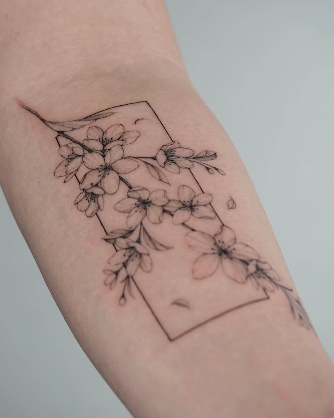 Elegant cherry blossom tattoo in minimalistic style