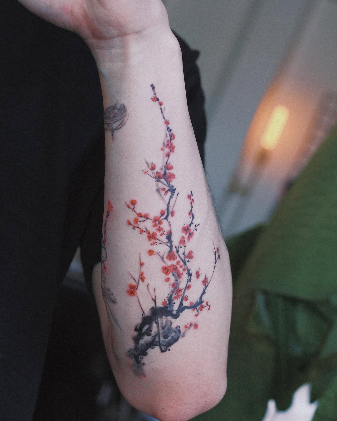 Elegant cherry blossom tattoo on a woman's arm