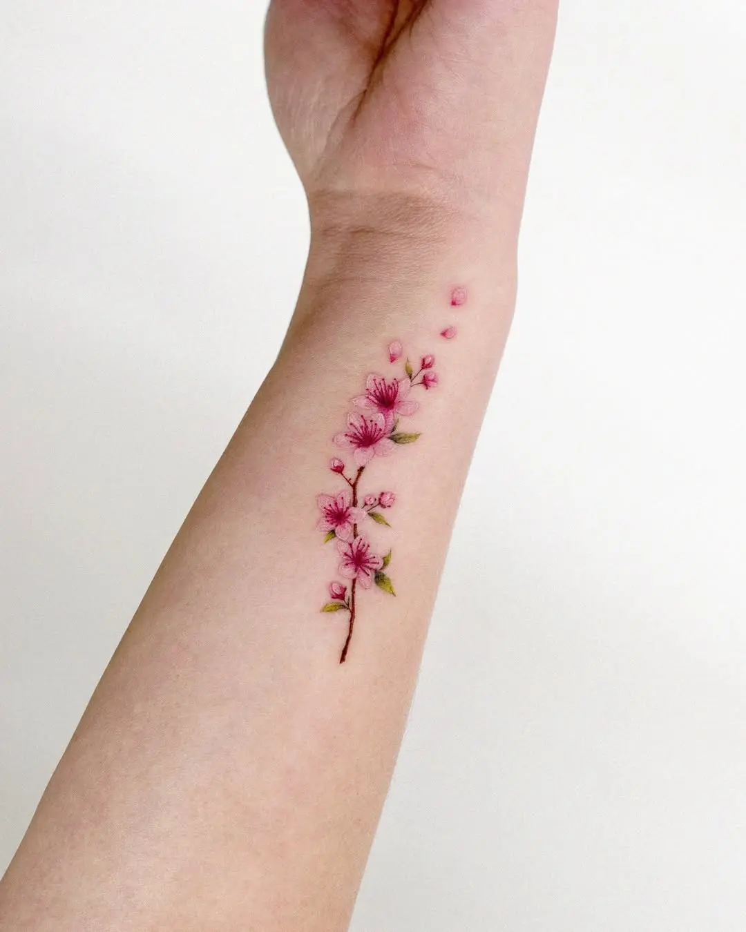 Delicate cherry blossom tattoo on the arm