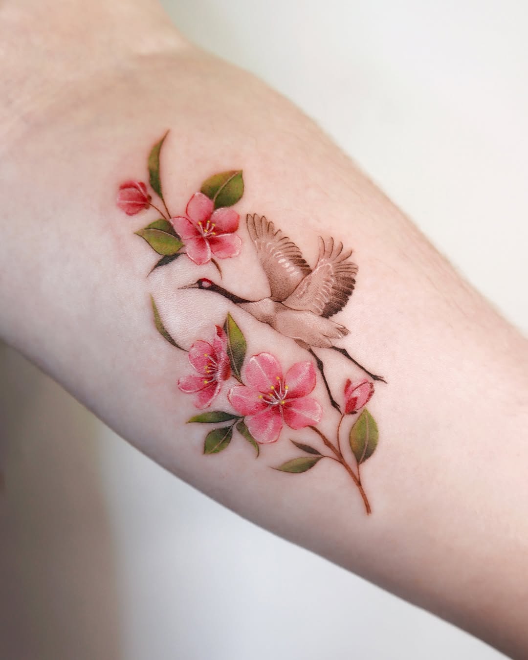 Elegant cherry blossom tattoo with a flying bird