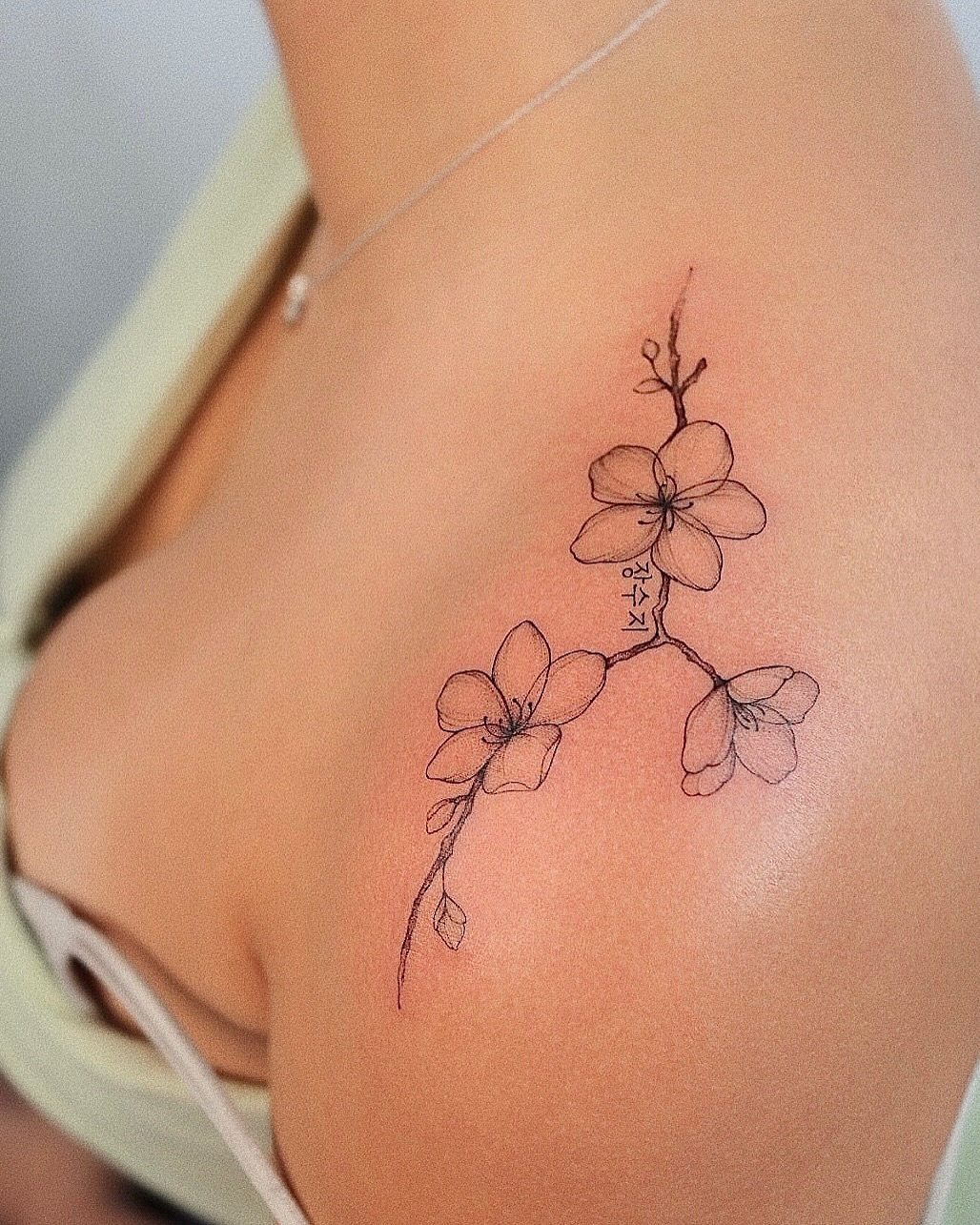 Elegant cherry blossom tattoo on shoulder