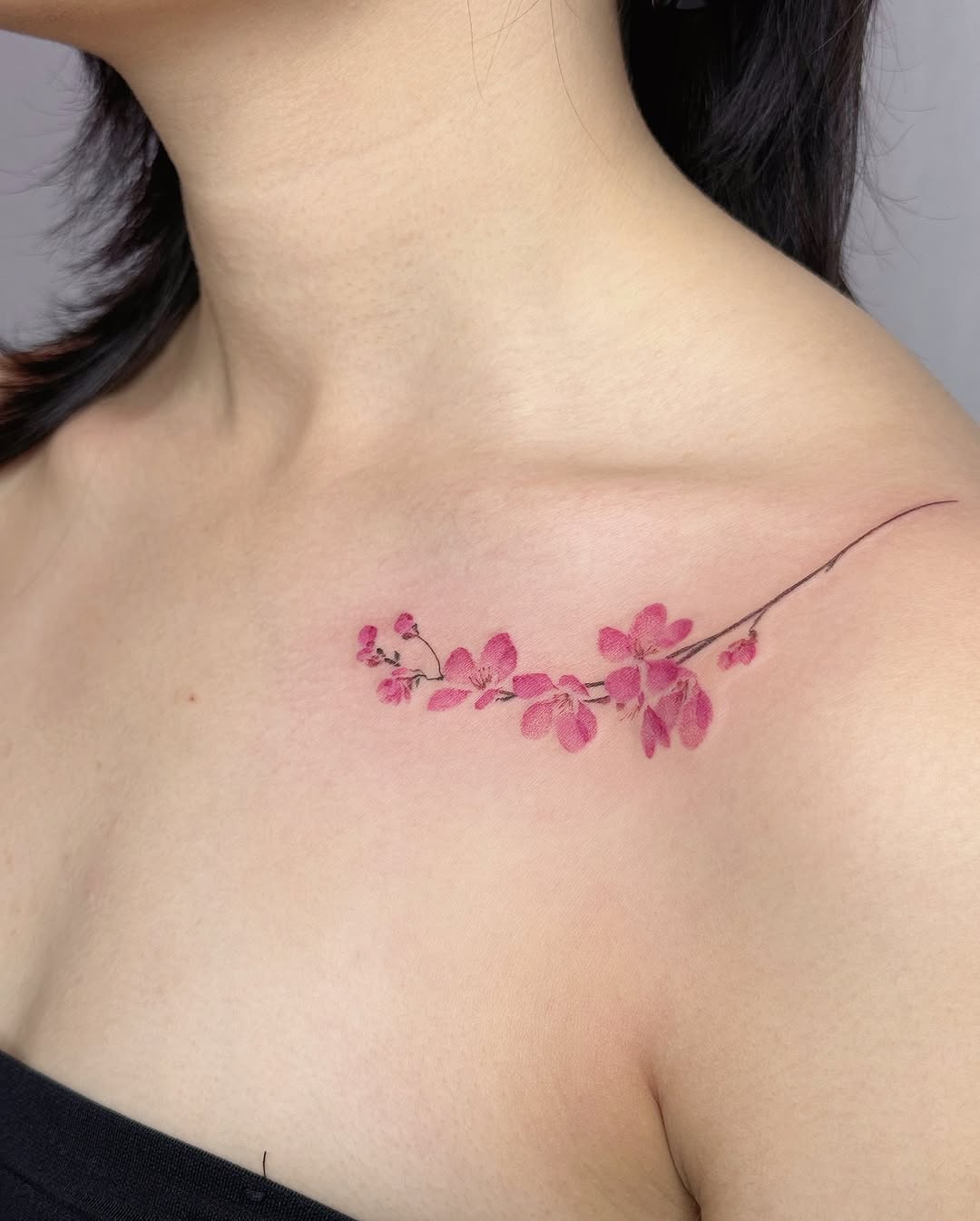 Delicate cherry blossom tattoo on shoulder