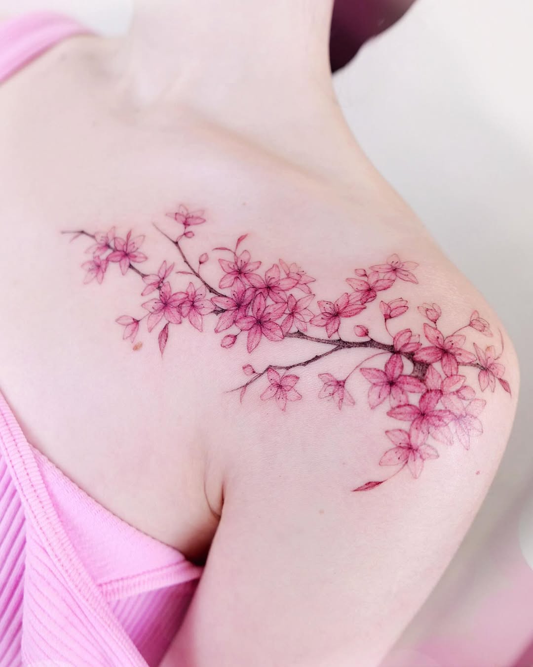 Delicate cherry blossom tattoo on shoulder.