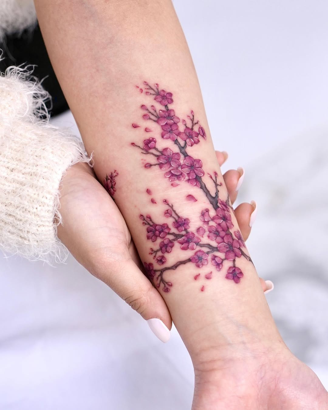 Elegant cherry blossom tattoo on forearm