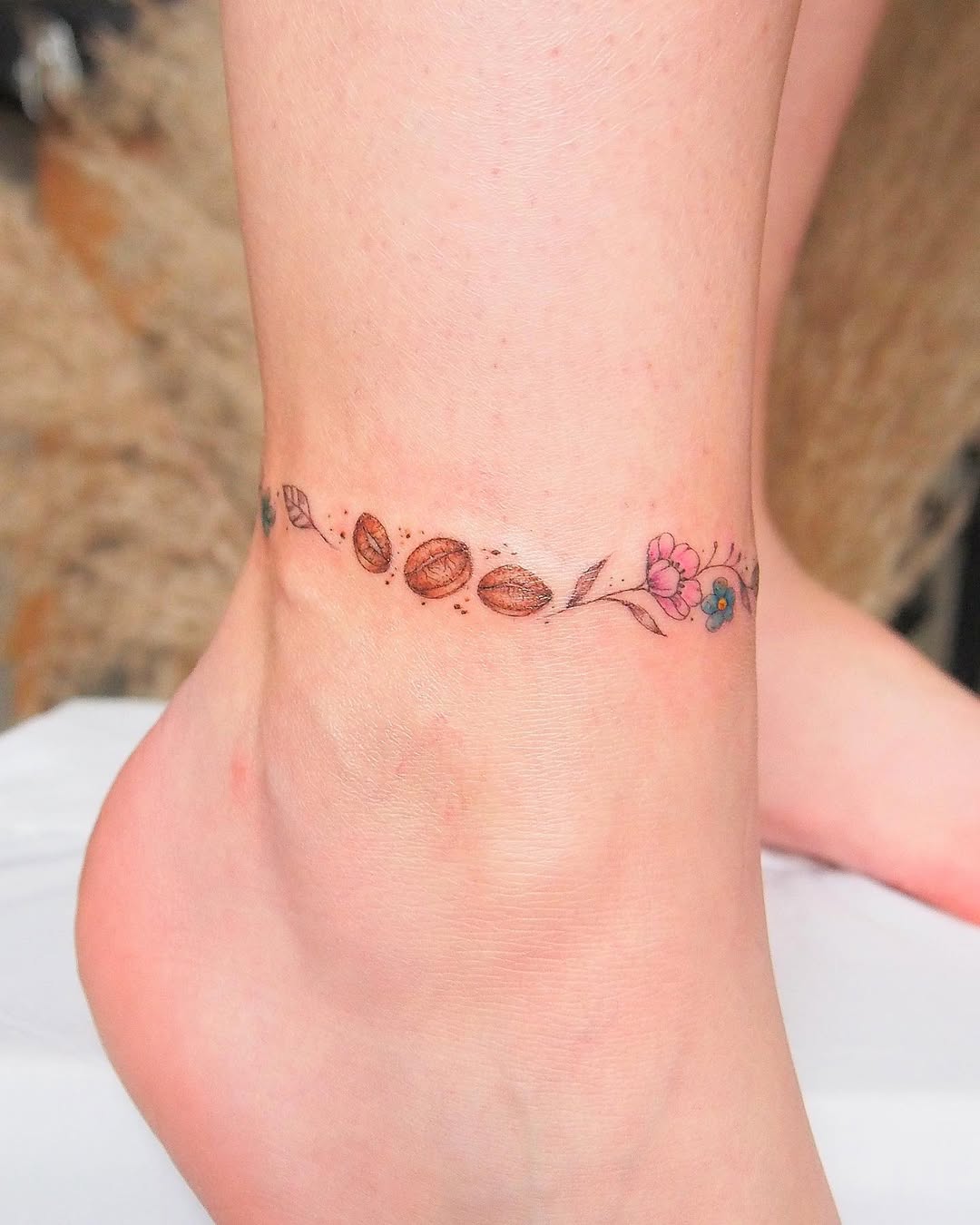 Delicate coffee bean and floral ankle tattoo