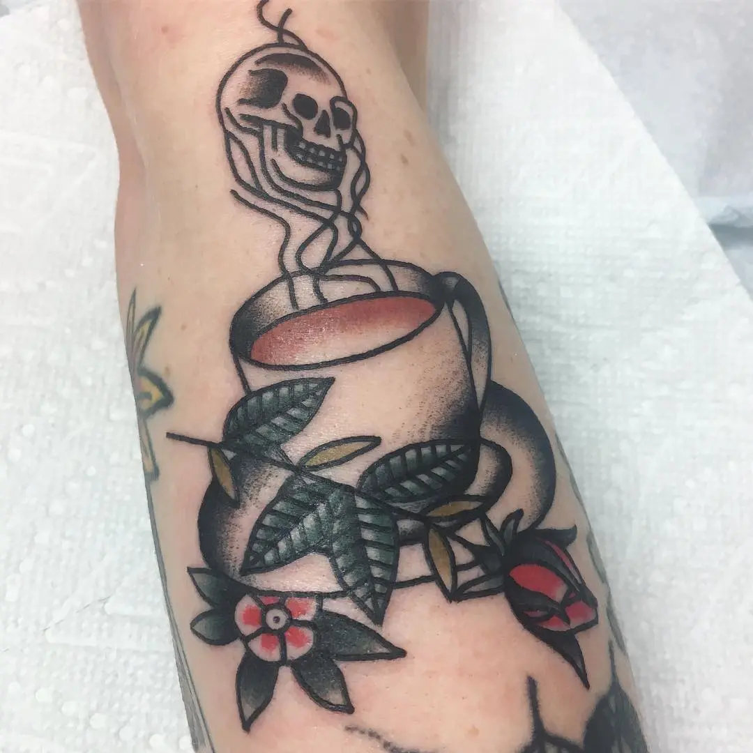 Unique skull coffee cup tattoo with floral accents