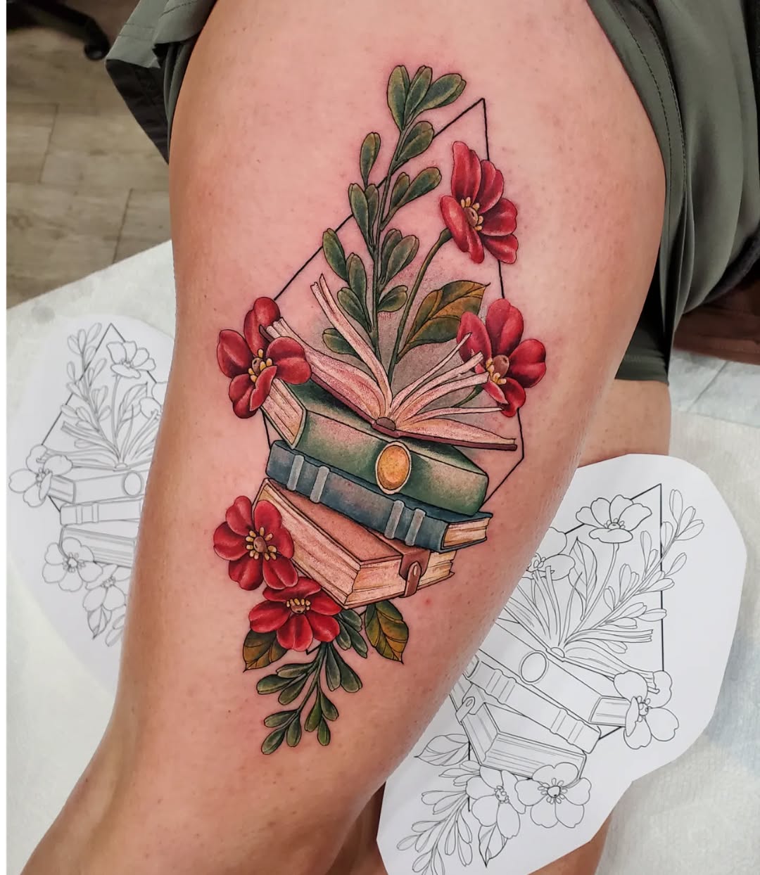 Vibrant floral book tattoo design on thigh