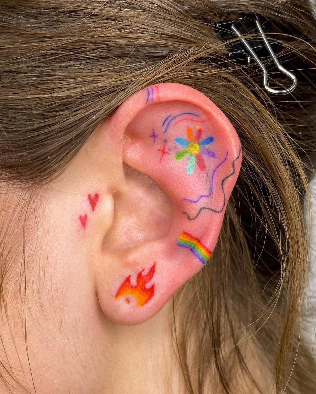 Vibrant ear tattoos with playful designs