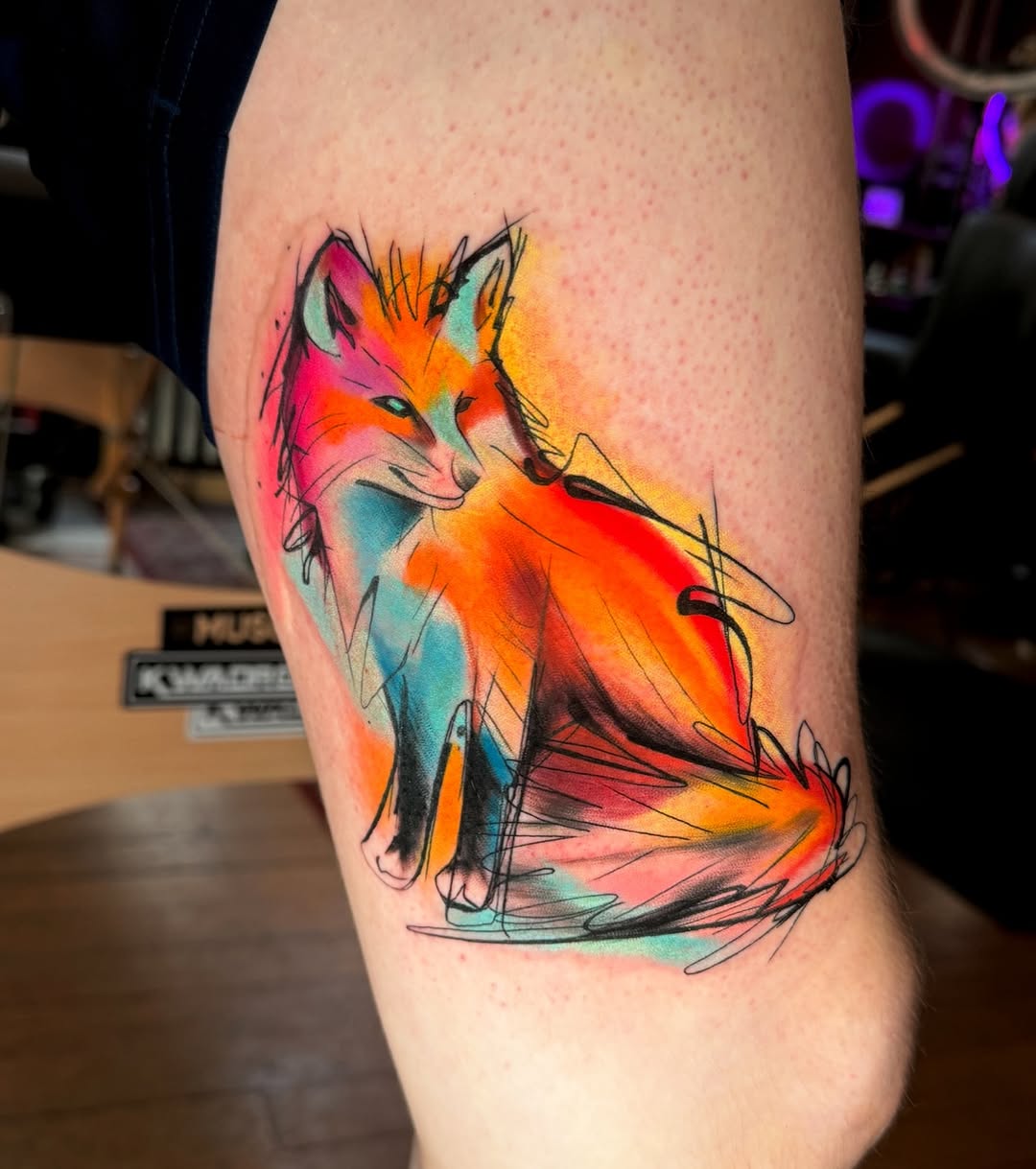 Vibrant watercolor fox tattoo with abstract flair