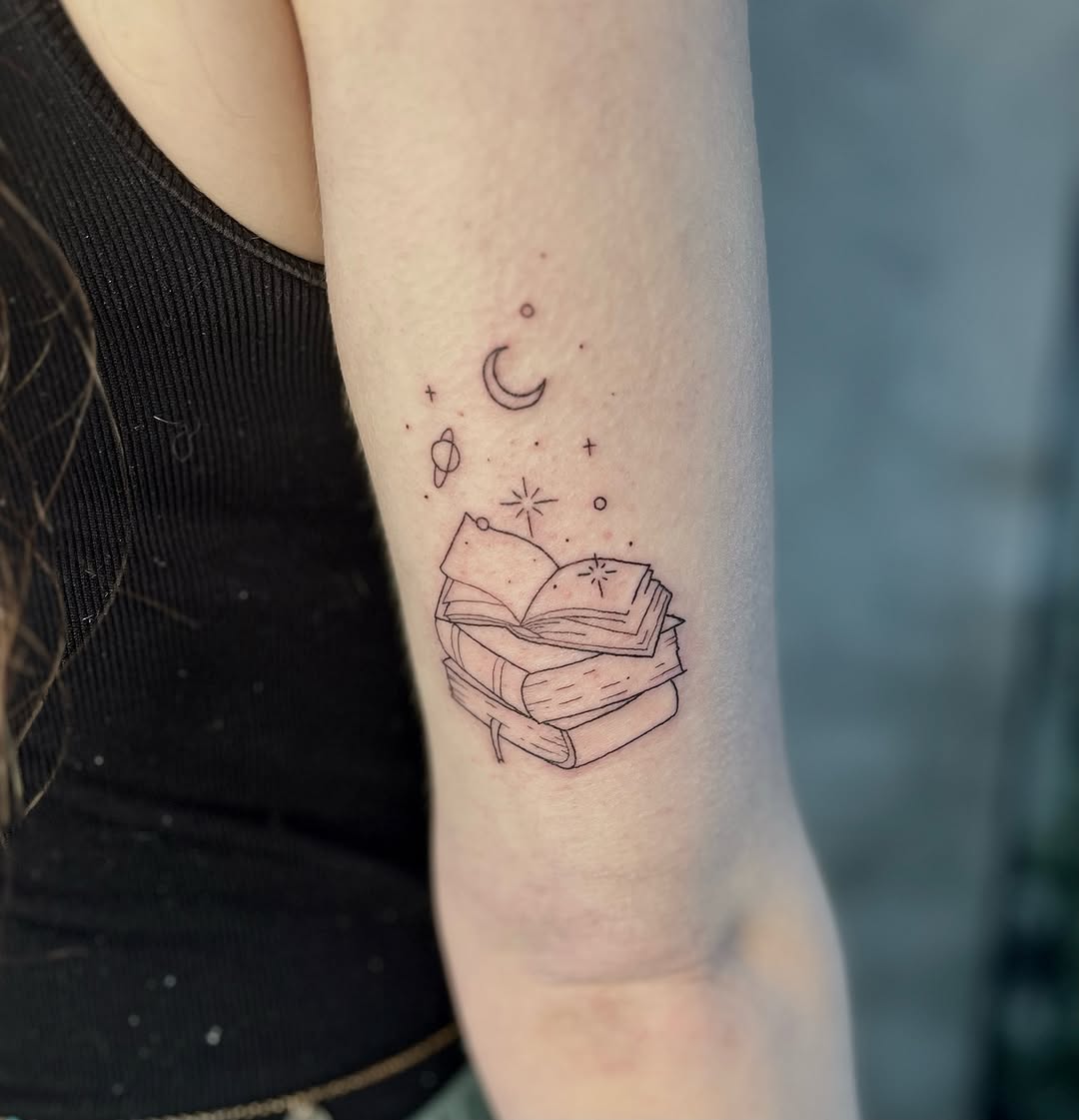 Charming tattoo of books with celestial elements