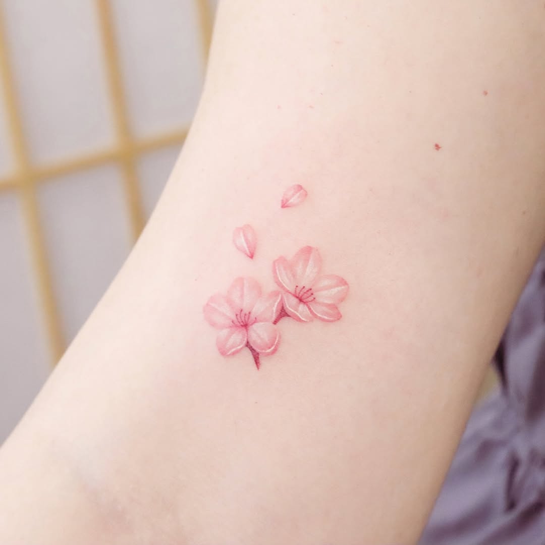 Elegant cherry blossom tattoo in soft pink hues