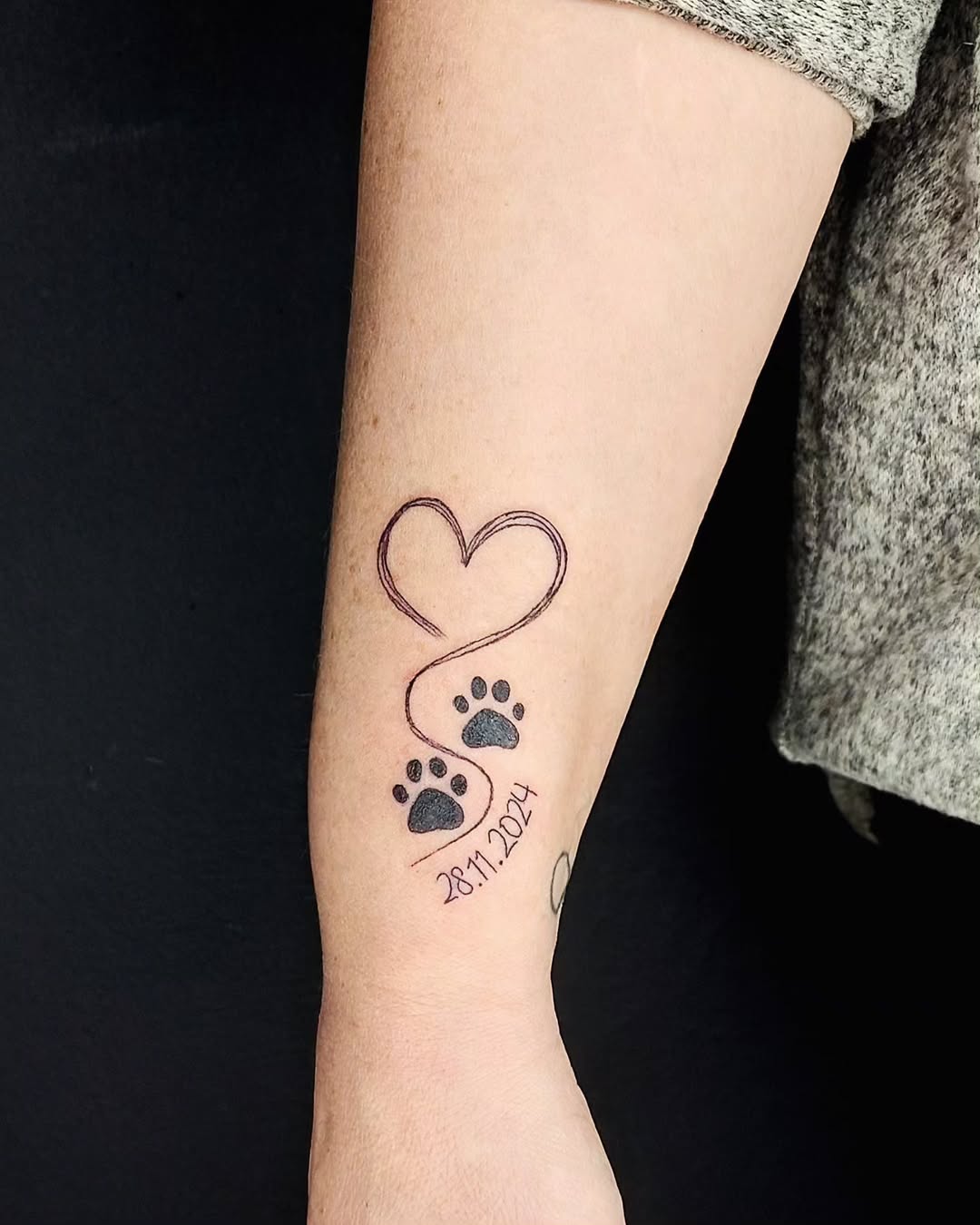 Meaningful dog paw print tattoo with heart