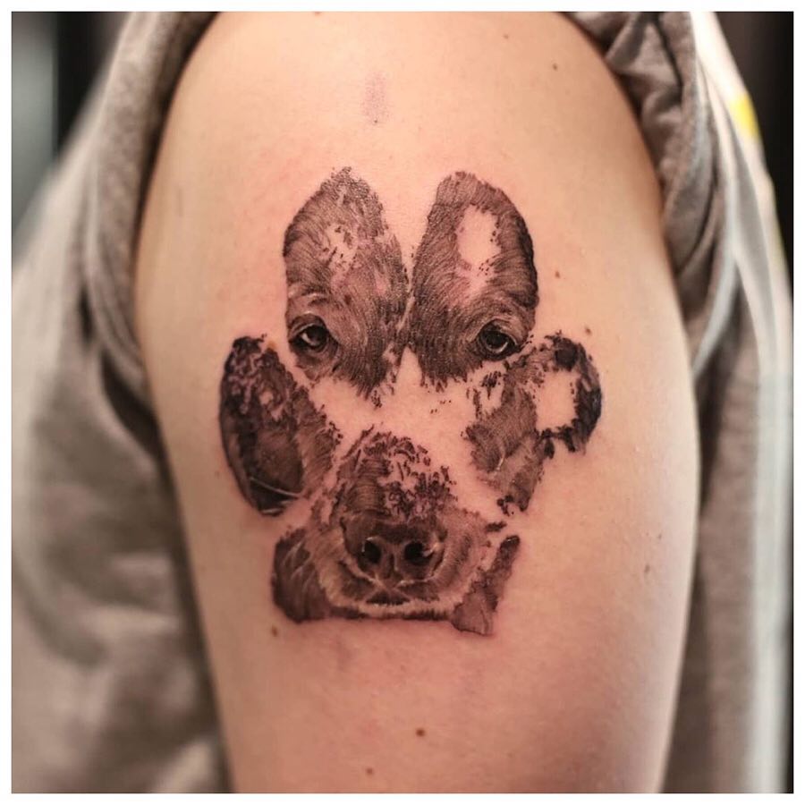 Unique paw print tattoo featuring dog faces