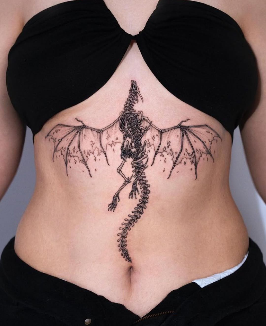 Elegantly crafted dragon skeleton tattoo design