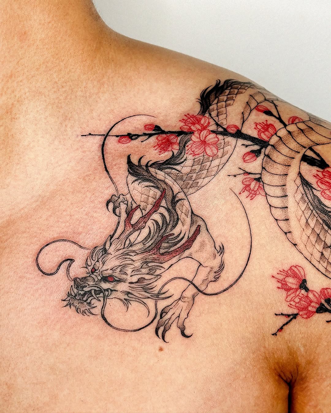 Bold dragon tattoo with floral elements