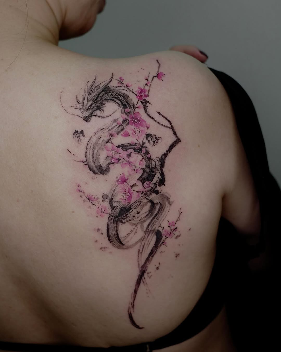 Stunning dragon tattoo with delicate cherry blossoms